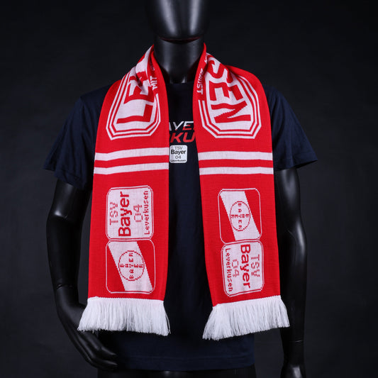Roter TSV-Bayer-04-Leverkusen-Fanschal mit weißen Fransen, großem LEVERKUSEN-Schriftzug und Vereinslogo, getragen von einer Schaufensterpuppe mit dunklem T-Shirt.