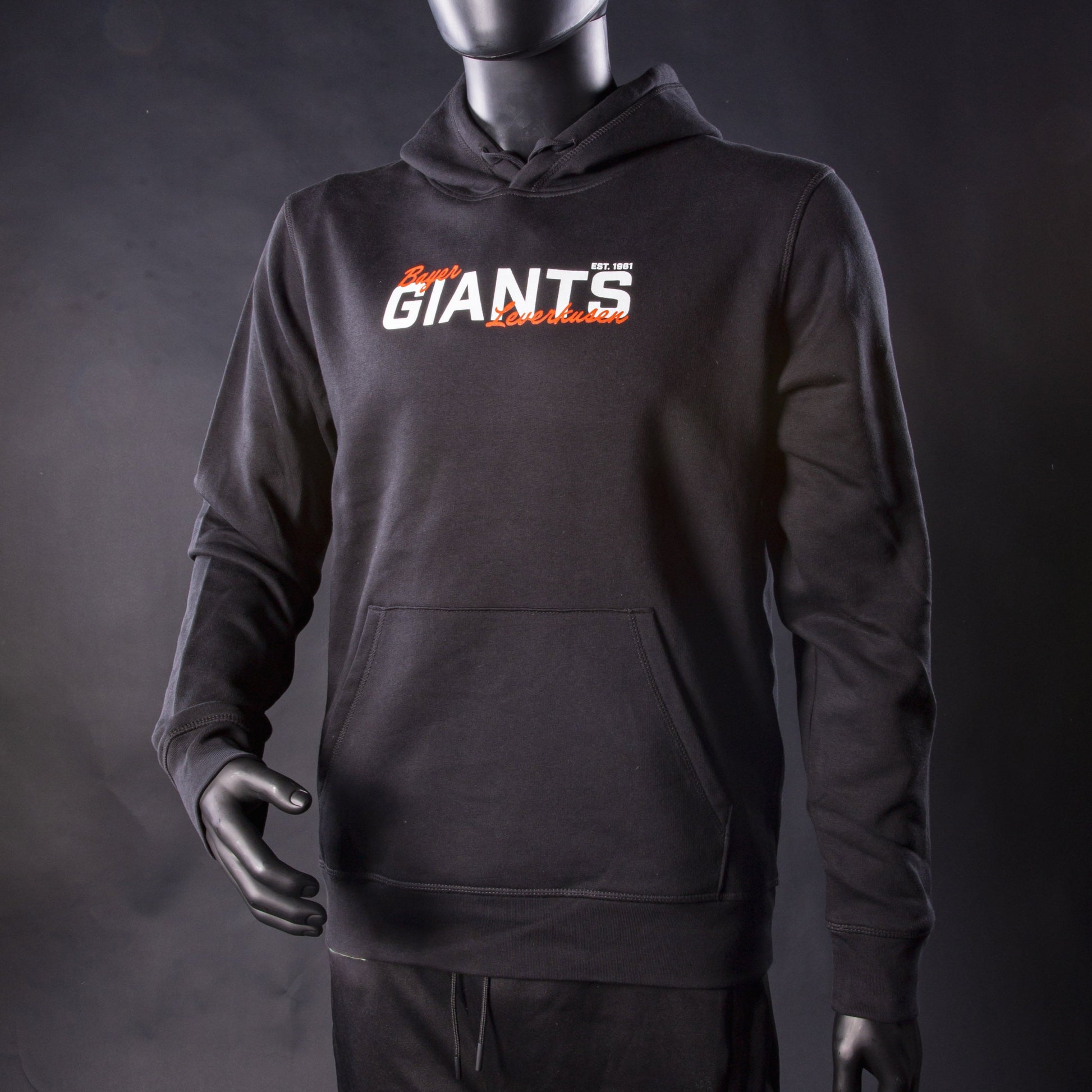Schwarzer Hoodie der Bayer Giants Leverkusen mit weiß-orange-rotem Schriftzug ‚Bayer Giants Leverkusen‘ auf der Brust, präsentiert an einer Schaufensterpuppe.